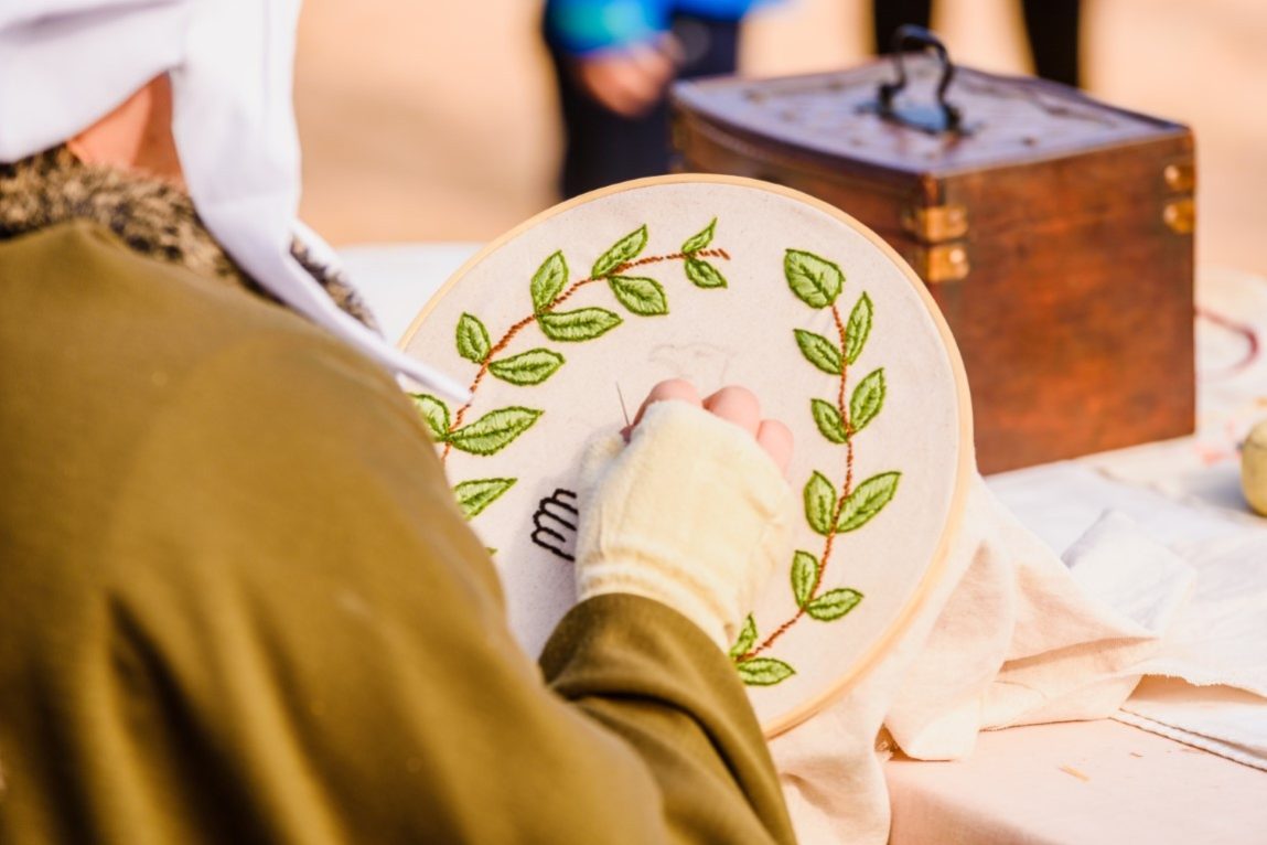 Young woman seamstress sewing a simple drawing, disguised as med
