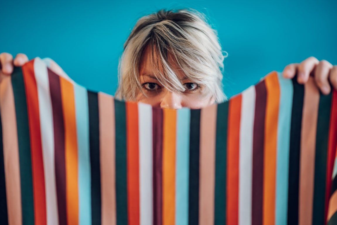 Portrait of a woman tailor holding colorful fabrics