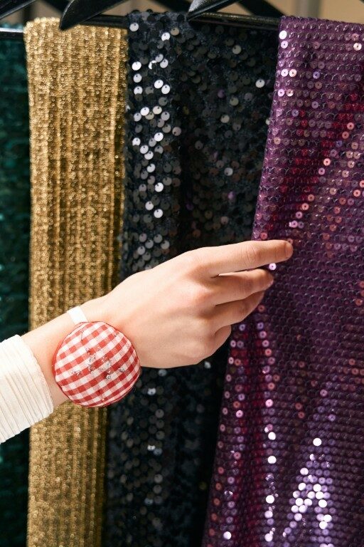 Close up of seamstress touches a purple shiny fabric