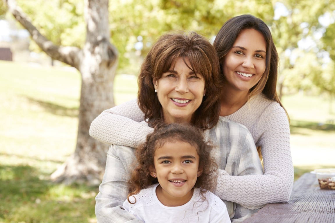 Three generations of women at a family picnic in a park