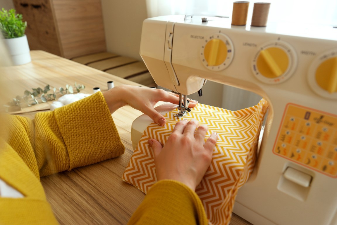 A woman sits at the sewing machine