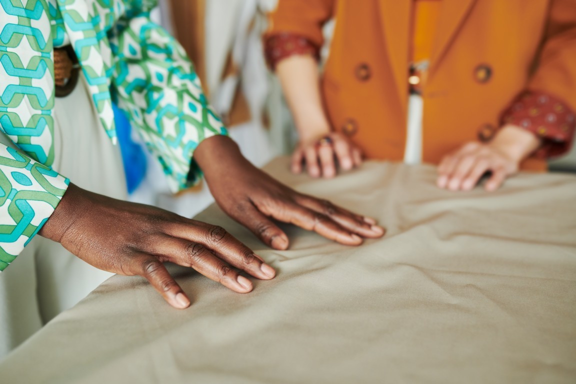 Hands of designer touching grey textile