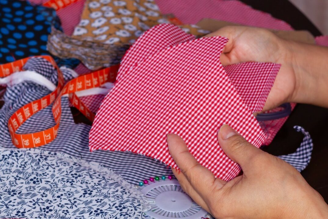hands-holding-red-fabric-with-other-fabric-around-2026-03-18-09-50-03-utc
