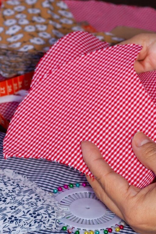 hands-holding-red-fabric-with-other-fabric-around-2026-03-18-09-50-03-utc