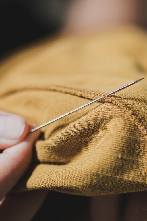 Woman fingers threading a needle